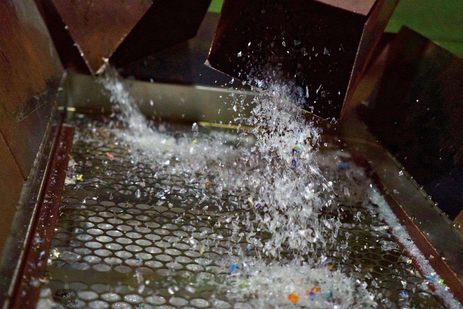 Water splashing over a metal grate in a recycling process.