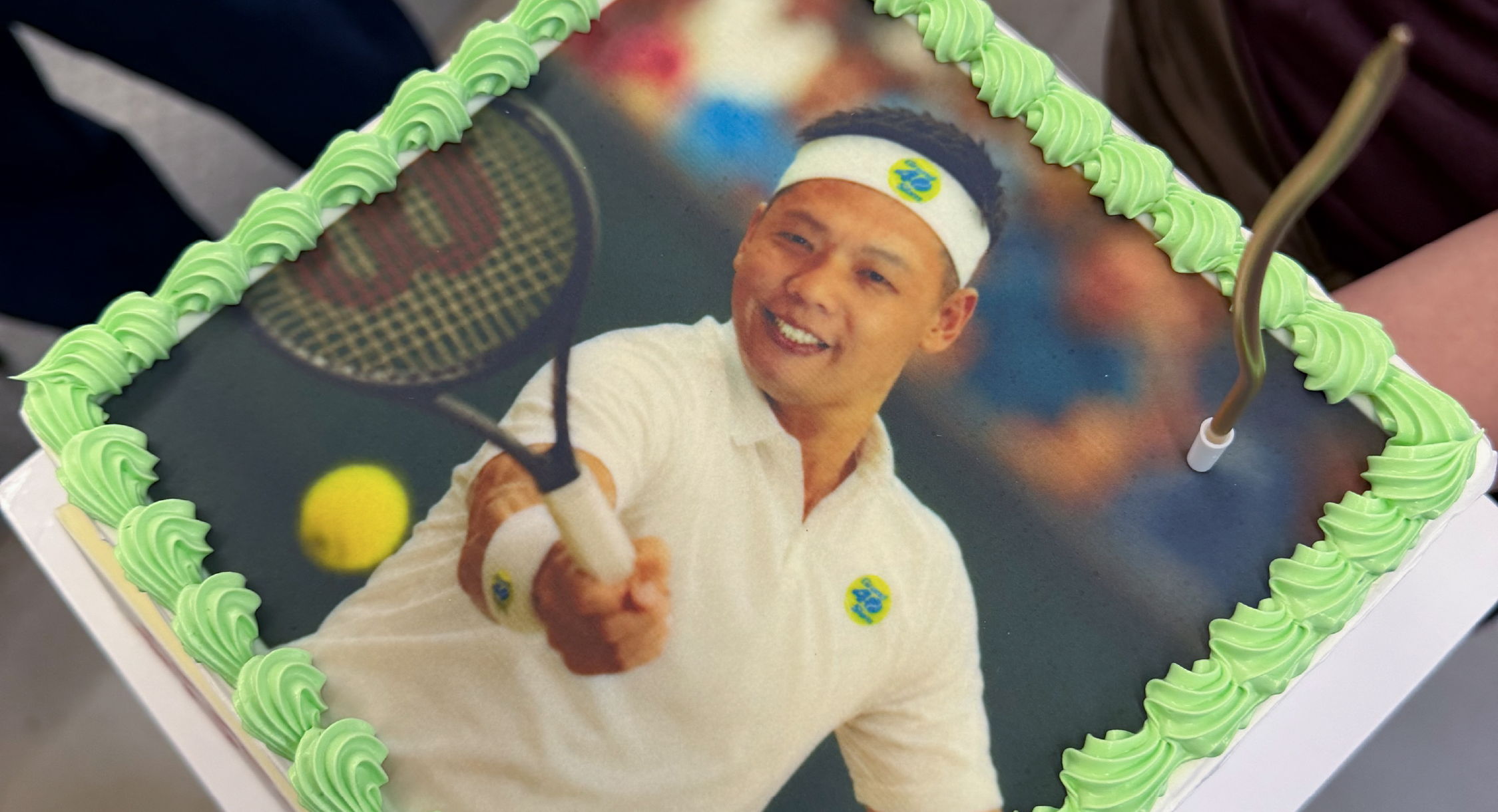 Tennis-themed cake featuring a player with a racket and tennis ball.