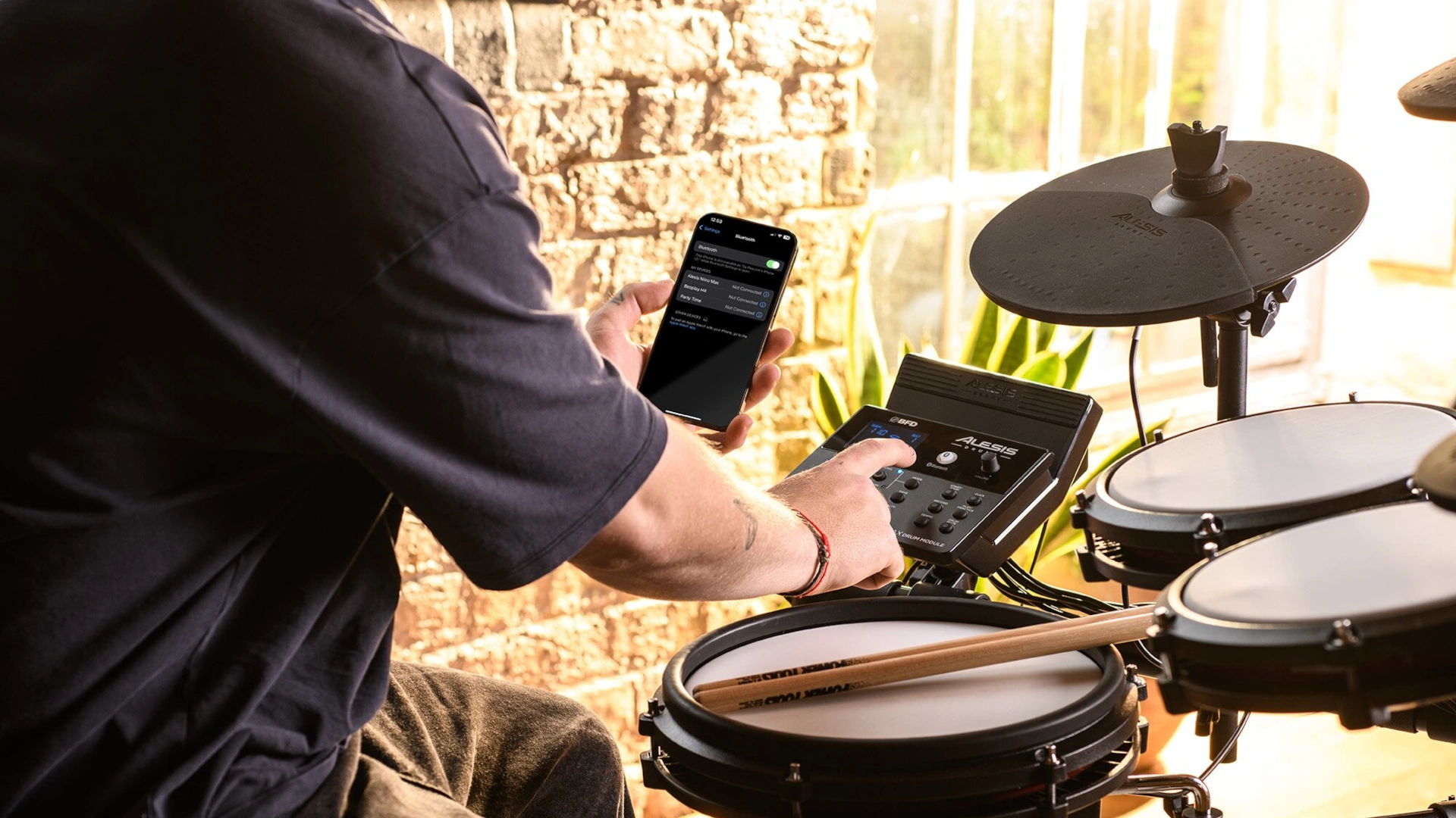 Person playing electronic drums while using a smartphone.