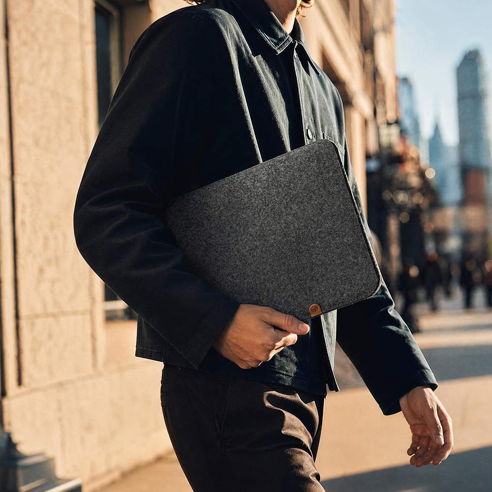 Ein Mann hält eine Macbook Neo Hülle aus Filz von Good Wilhelm in der Hand