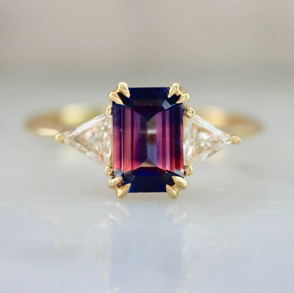 bi-color emerald cut pink sapphire ring with trillion side stones