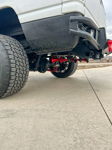 Four red air horns mounted behind rear axle on lifted truck with heavy-duty bumper