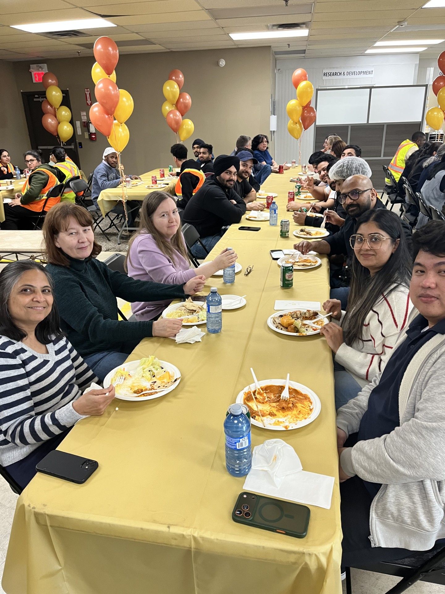 Group of people enjoying a meal at a long table with decorations.