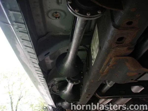 Underbody angle showing twin black train horn bells mounted along the frame rail on Jerry's Silverado, install photo 8