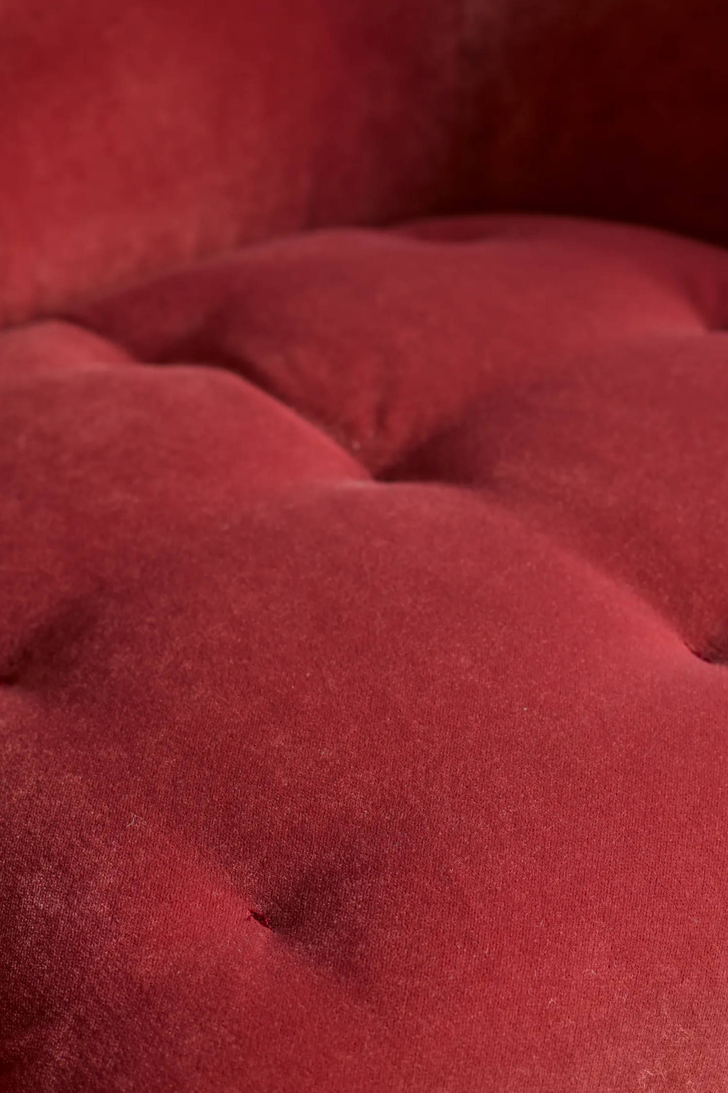 Close up of pink blind button armchair seat.
