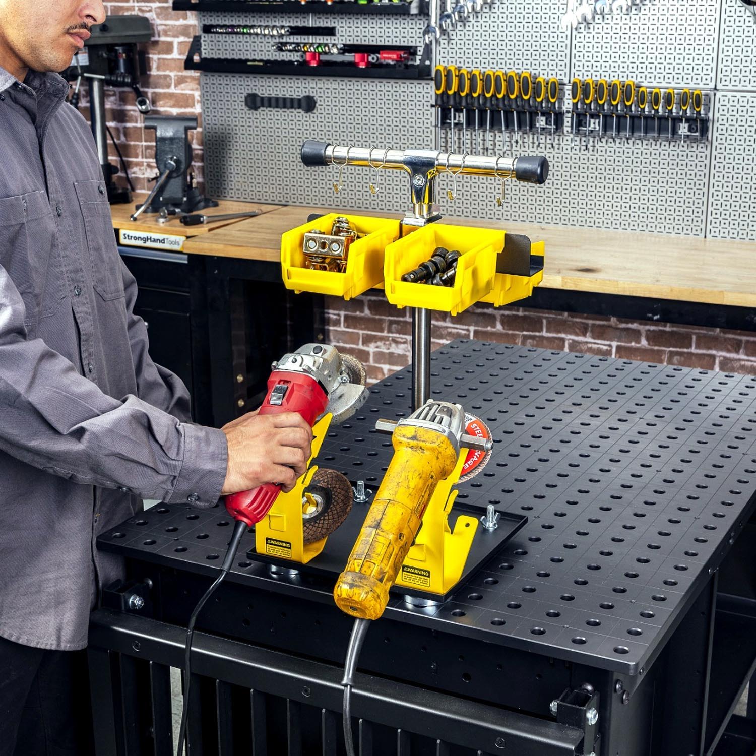 Person using power tools on a workbench in a workshop setting.