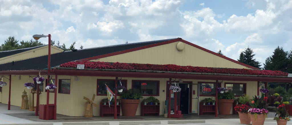 Deneweth's Hartland storefront with red flowers planted along the roof