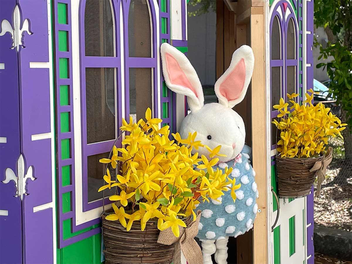 Decorated Custom Wooden Playhouse with Easter bunny in a backyard by WholeWoodPlayhouses