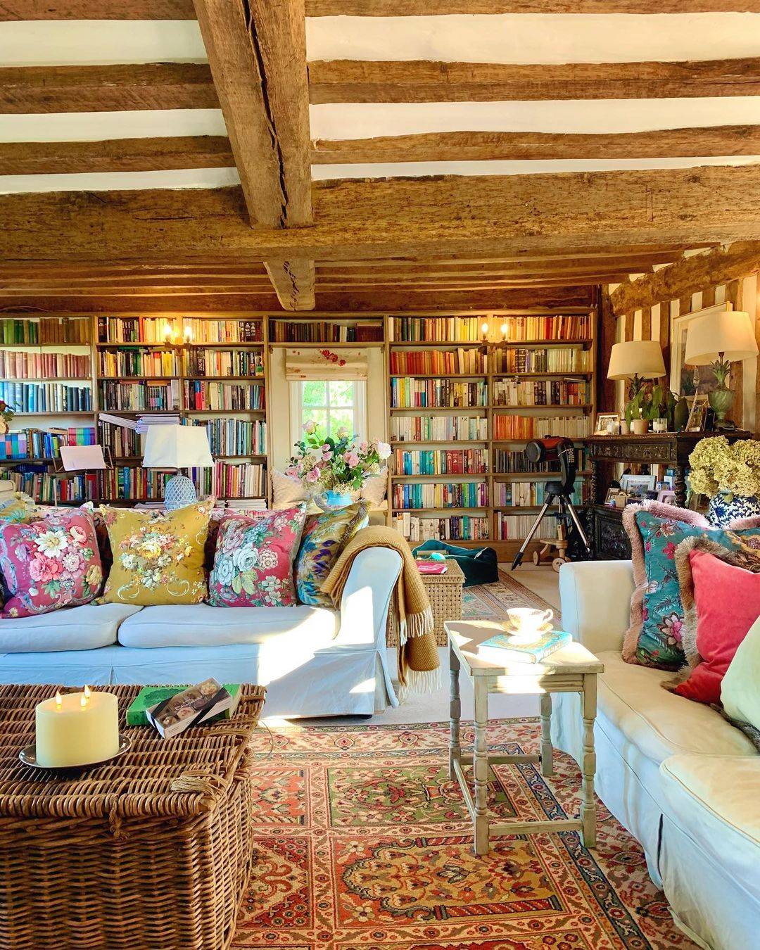 a living room filled with books and a three wick TruGlow® candle.