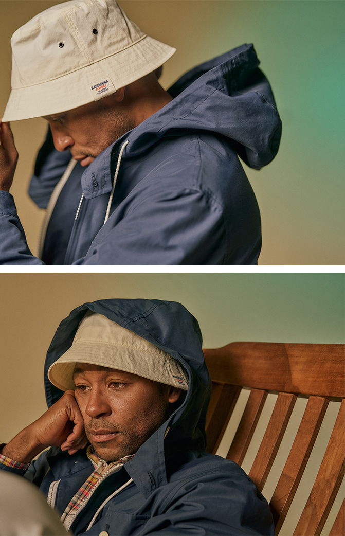 A person in a bucket hat and jacket, looking contemplative.