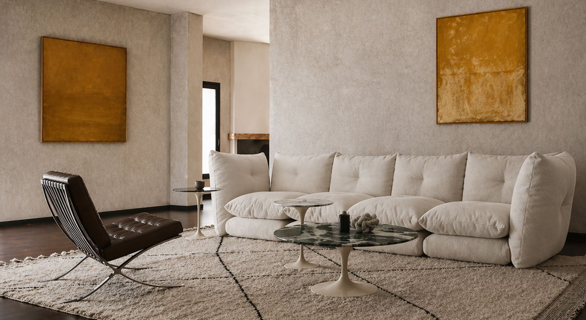 Modern living room with white sectional sofa, glass table, and abstract art.