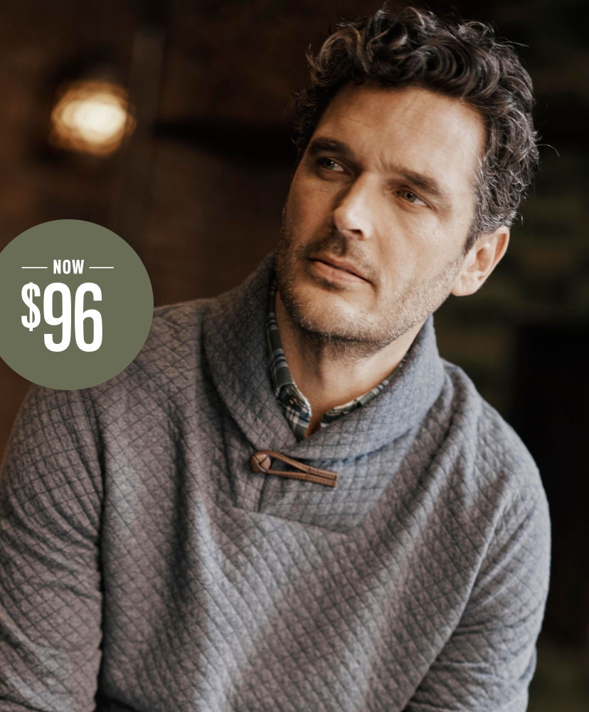 Man in gray sweater with price tag reading $96.