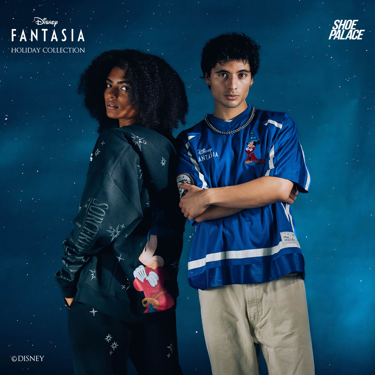 Two young individuals posing back-to-back against a blue background.