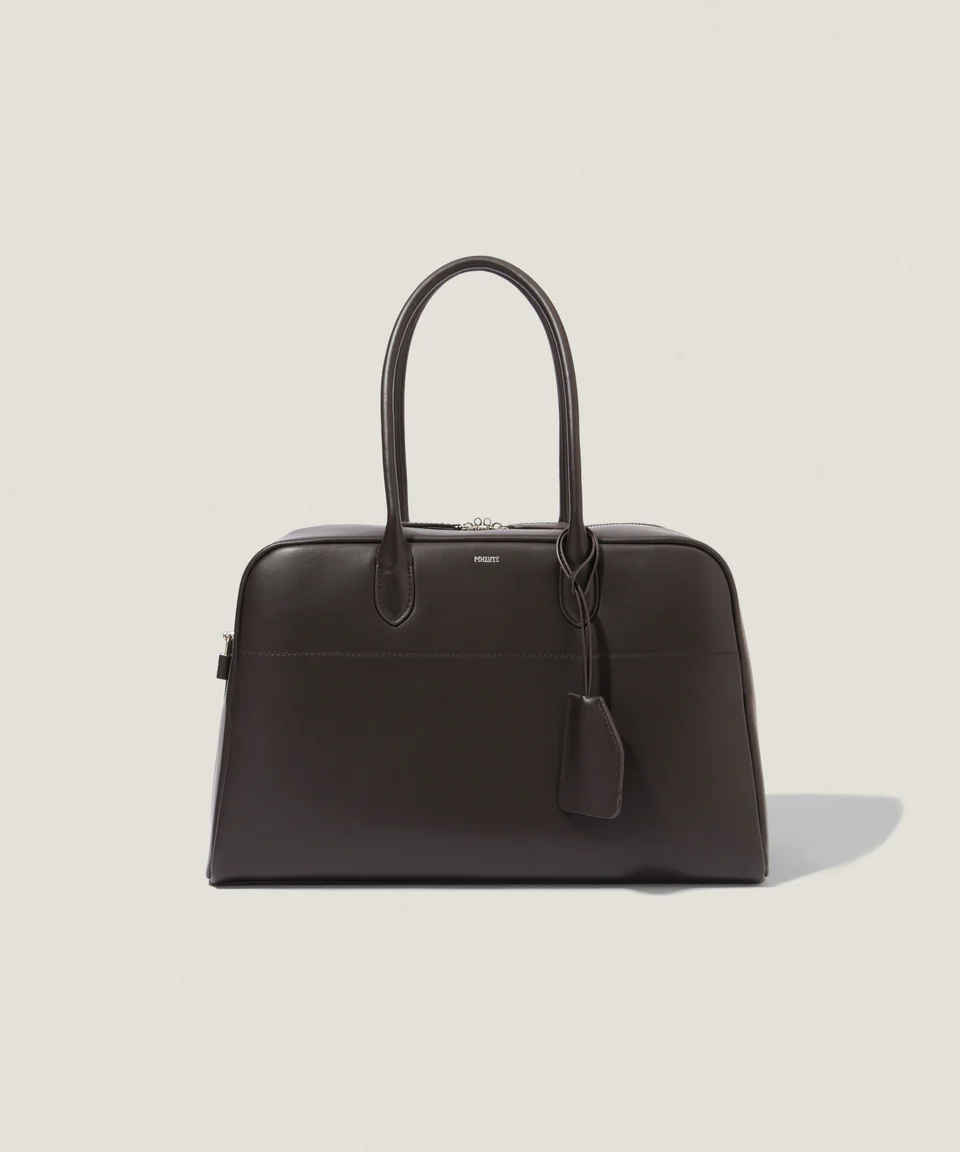 A dark brown handbag with handles and a tag.