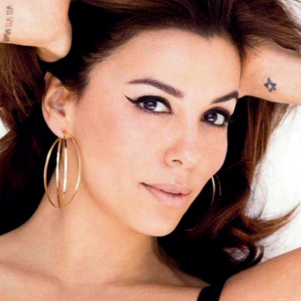 Woman with long hair and hoop earrings posing confidently.