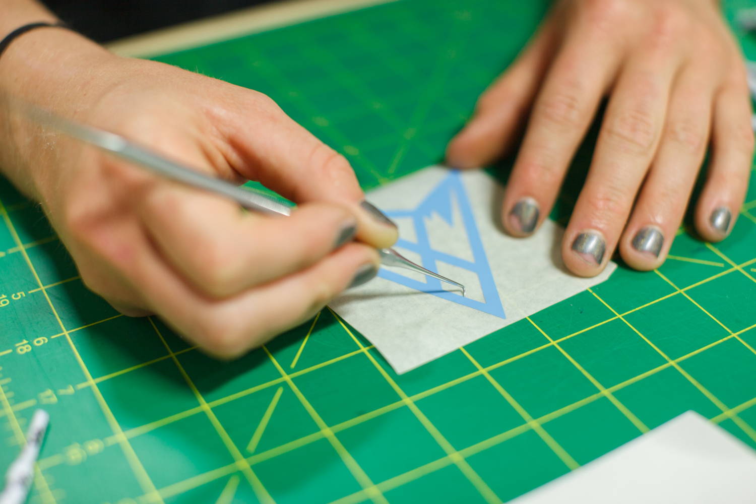 Weeding a sheet of cut vinyl stickers.