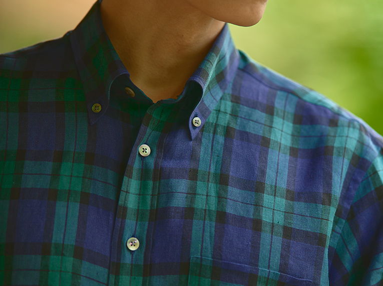 Person wearing a green and blue plaid shirt, partially visible.