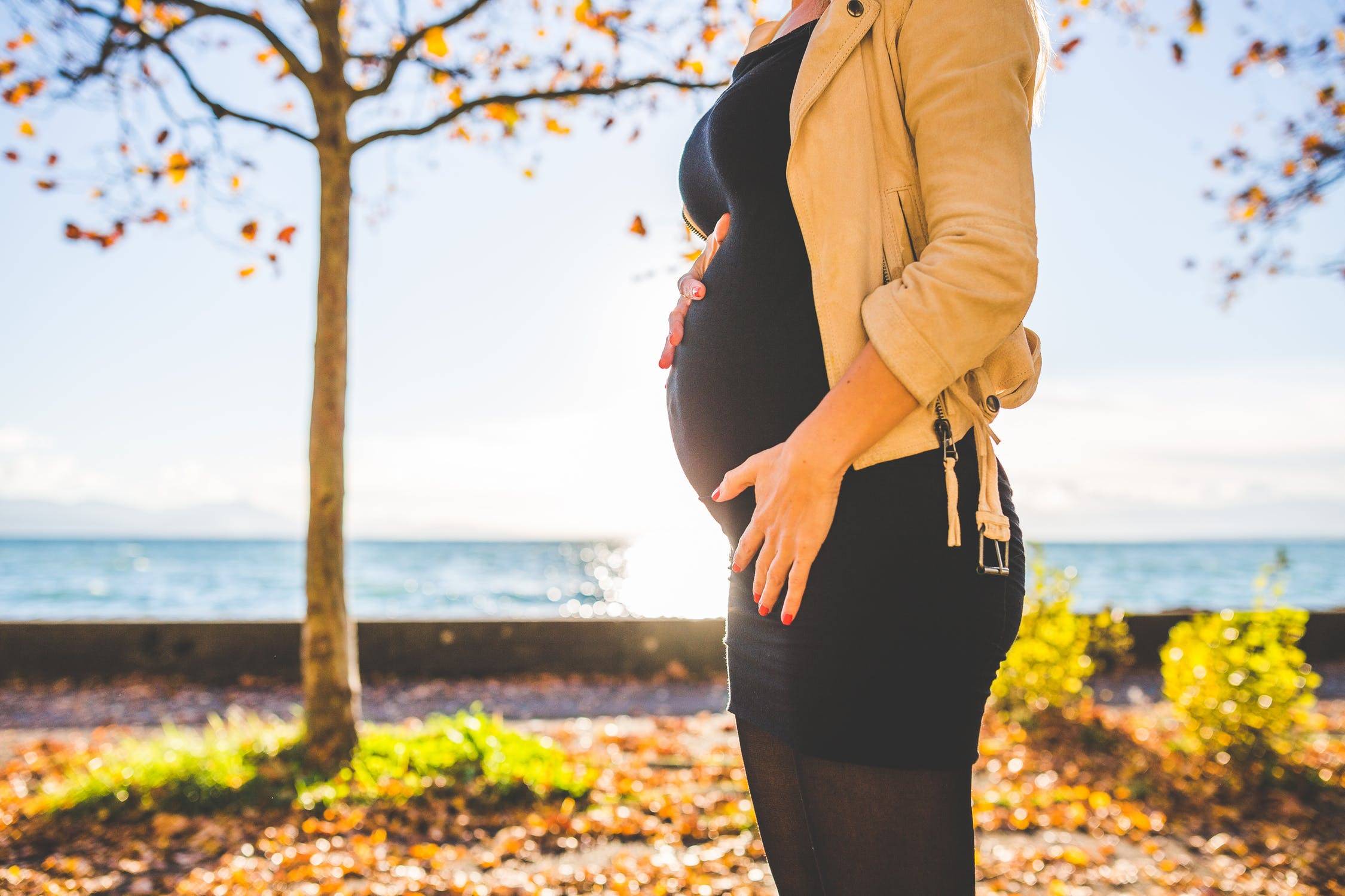 Pregnant Woman Wearing Beige Long sleeve Shirt Standing By The Sea