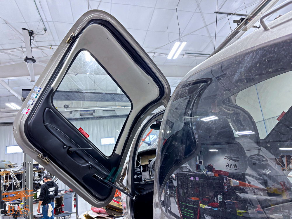 Car door partially open in a garage setting.