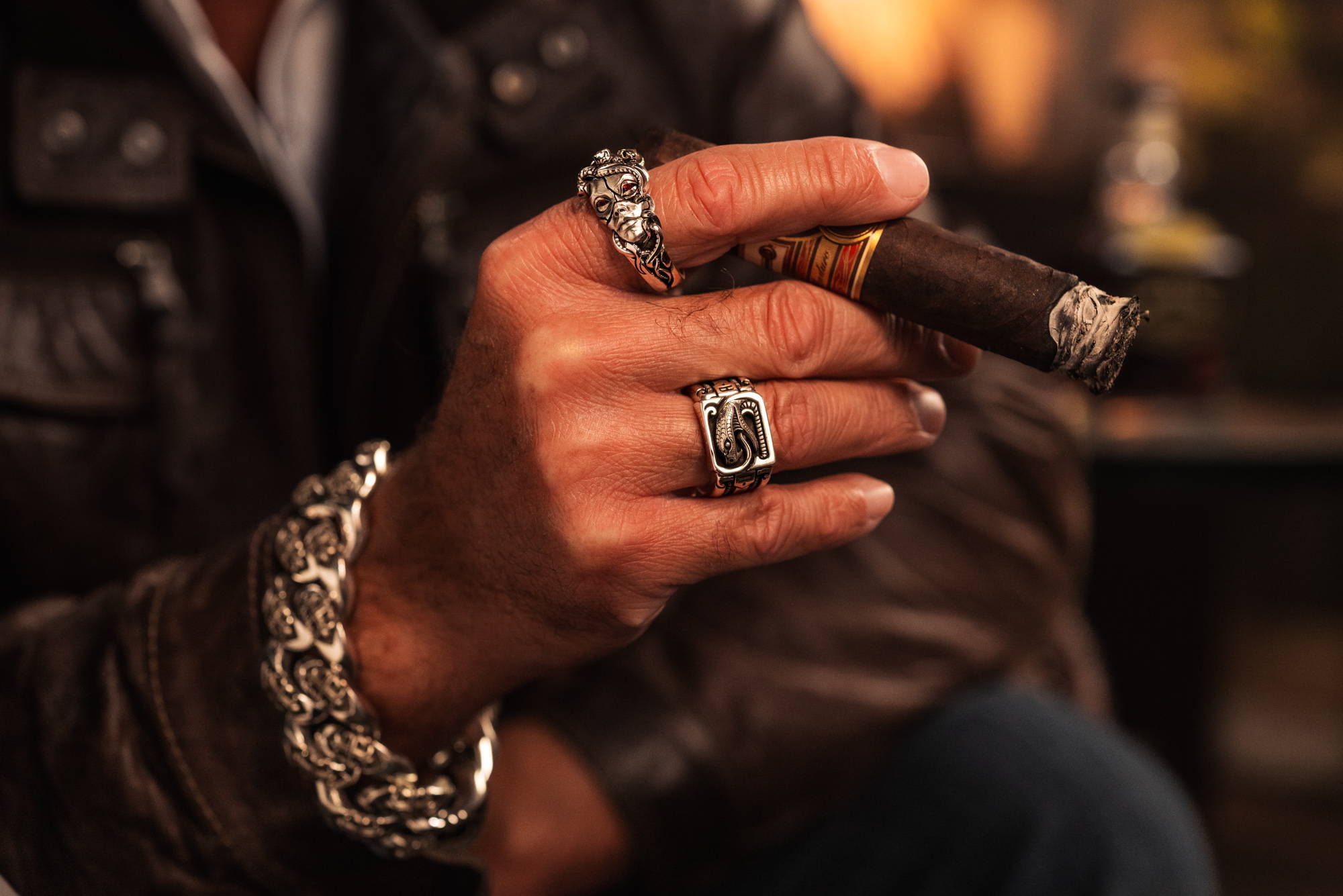 A man holding a cigar while wearing the Patrona Medusa Ring