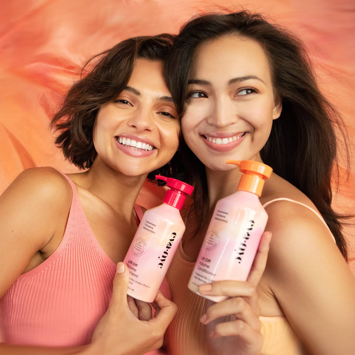 Models holding Lift Off Volume Shampoo and Conditioner