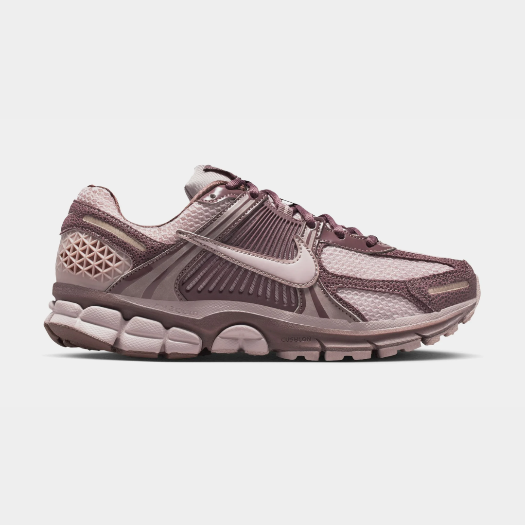 Nike athletic shoes in shades of purple and gray, side view.