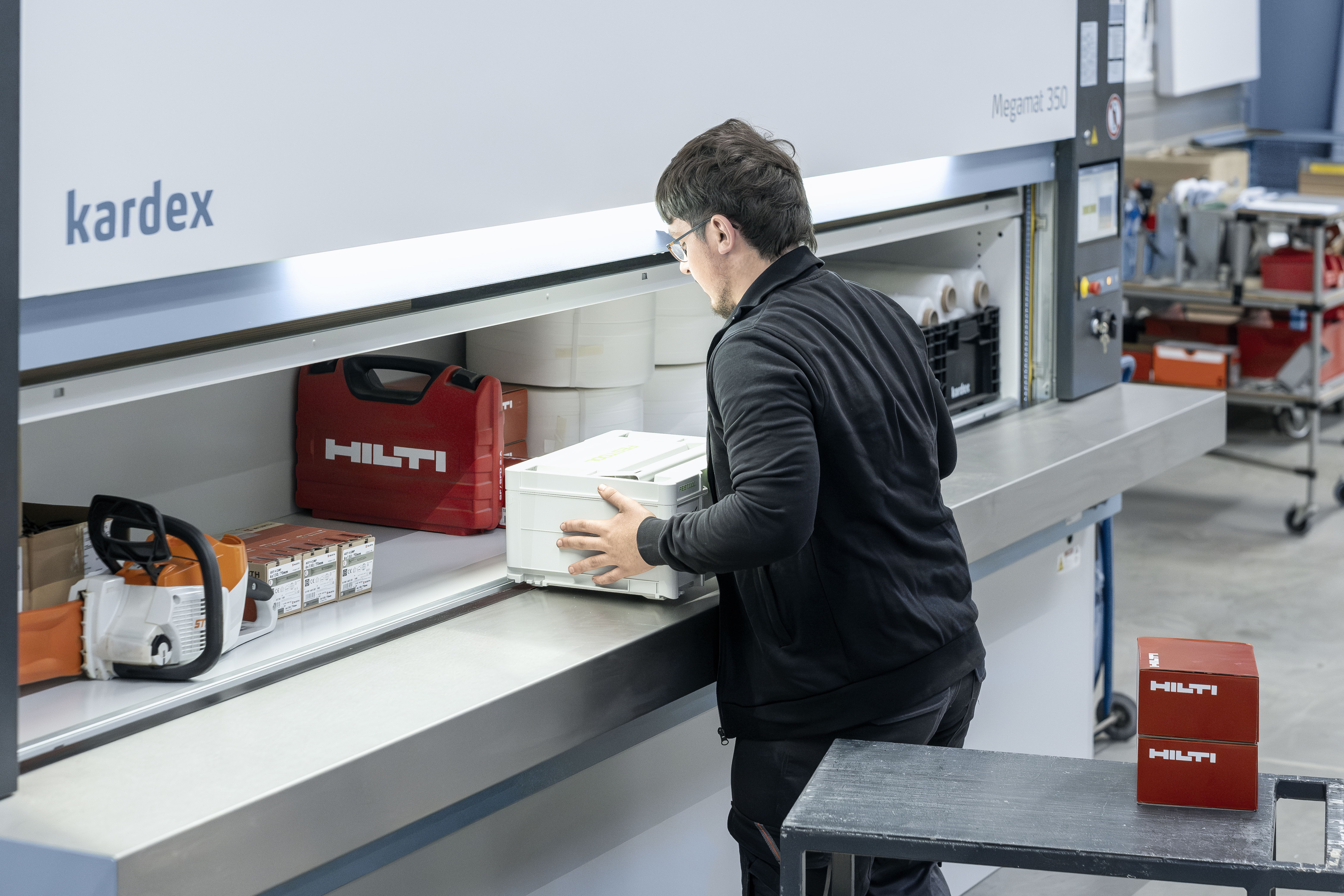 worker is adding inventory to shelf of Kardex VLM