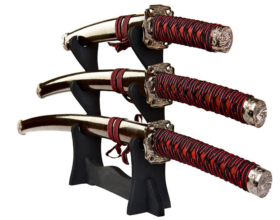 Three decorative swords displayed on a black stand.