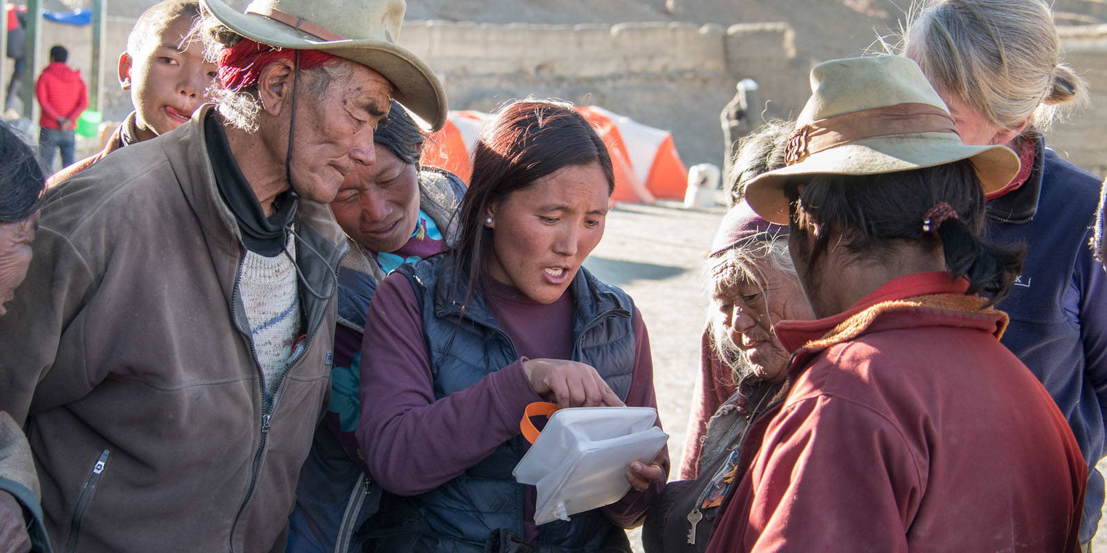 A woman explaining how to use a LuminAID light to a group affected by the Nepal Earthquake. 