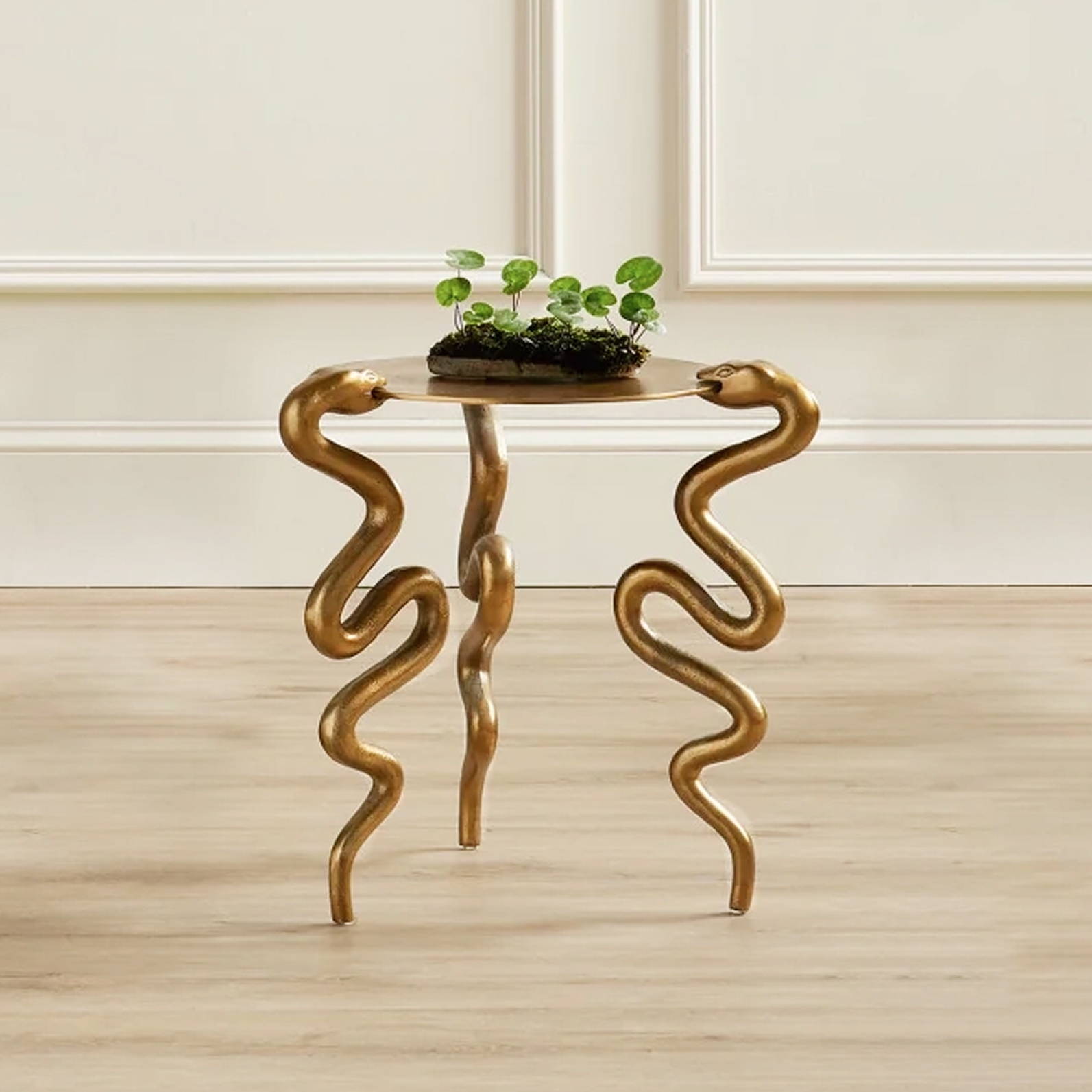 A unique table with snake-shaped legs and a small plant on top.