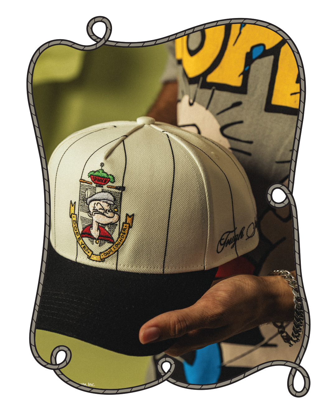A person holding a white and black baseball cap with a logo.