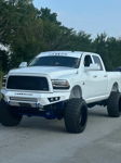 Front three-quarter view of lifted white Ram truck with Casper grille, MOVE bumper, and blue suspension accents
