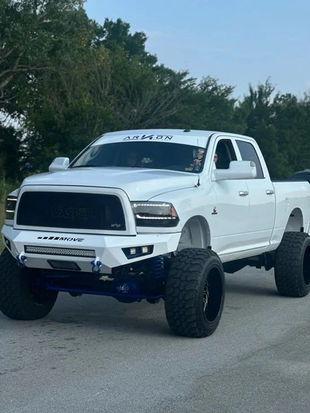 Front three-quarter view of lifted white Ram truck with Casper grille, MOVE bumper, and blue suspension accents
