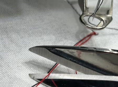 Closeup of cutting the bobbin thread