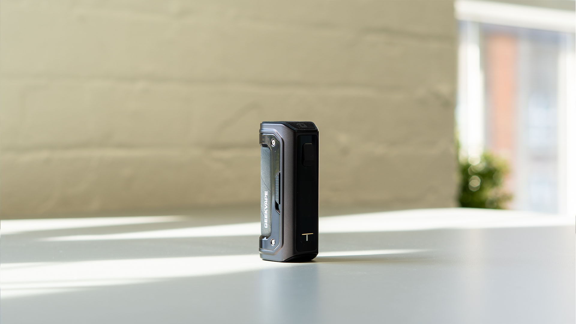 A black device standing upright on a table with natural light.