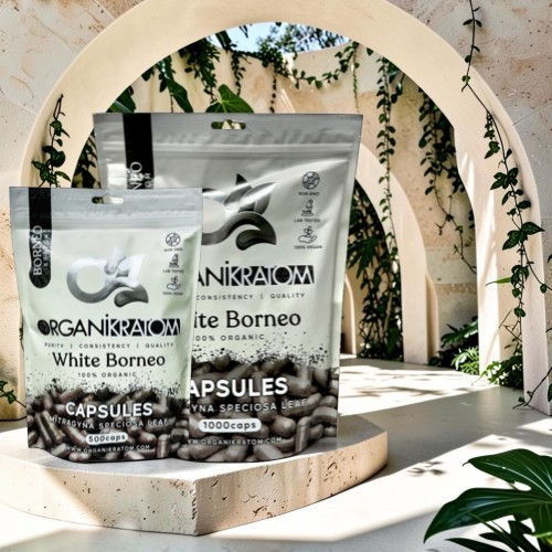 Bags of White Borneo capsules displayed in a lush, arched setting.