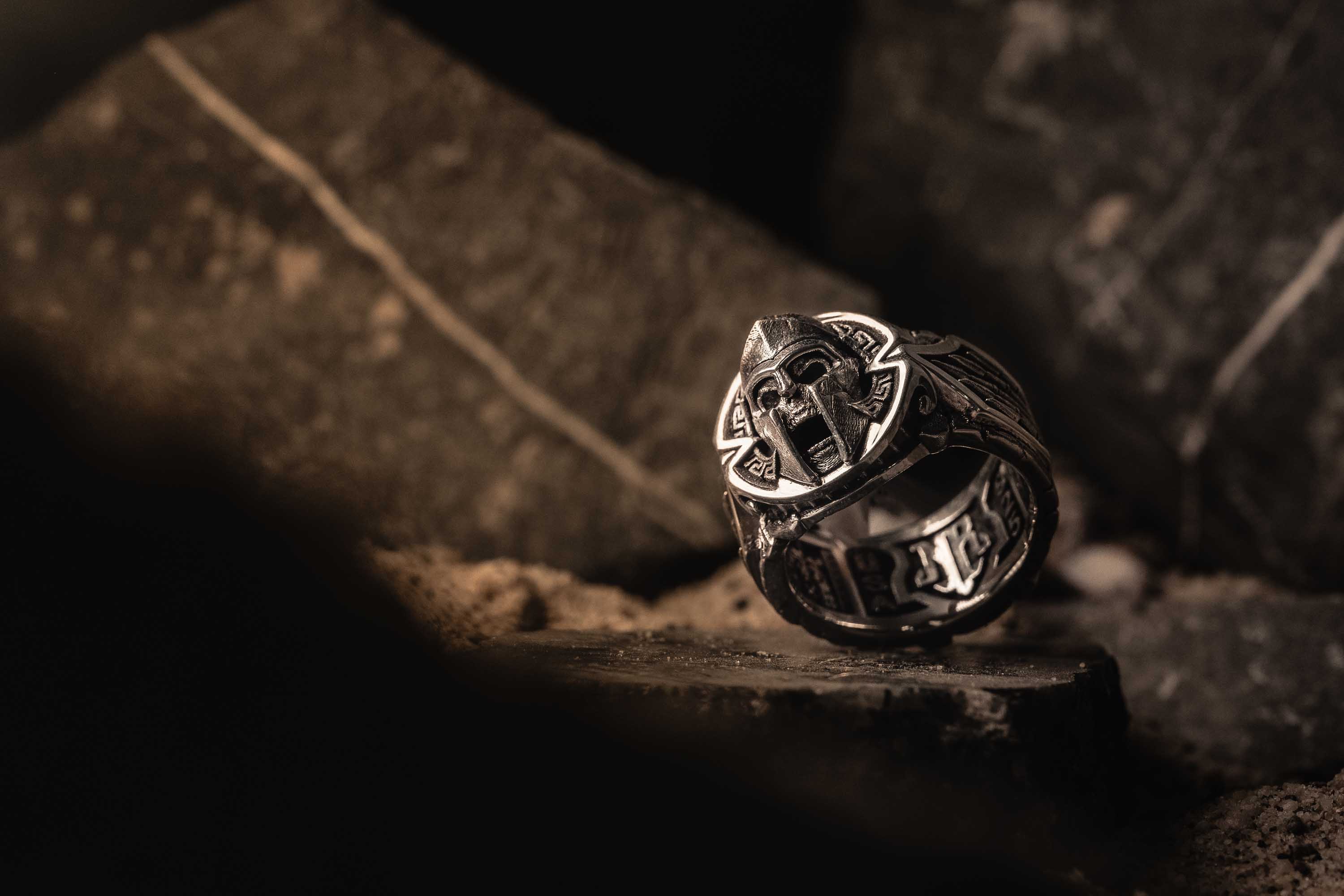 The Front of the Thermopylae Band Ring with a Screaming Skull in a Spartan Helmet, Surrounded by a Greek Key Design