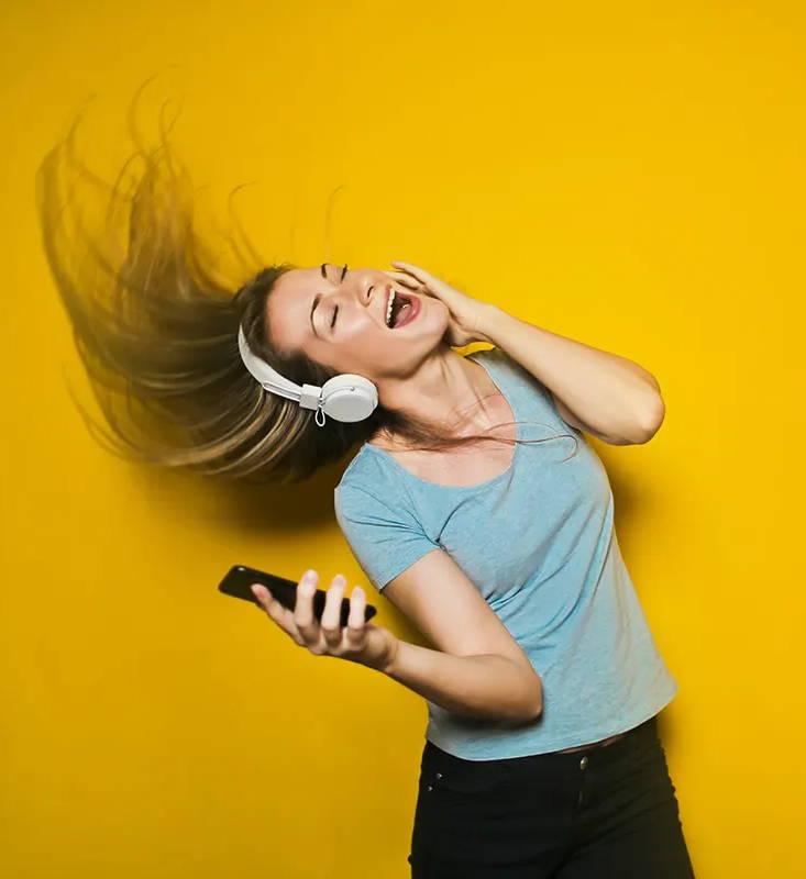 Exuberant woman listening to headphones