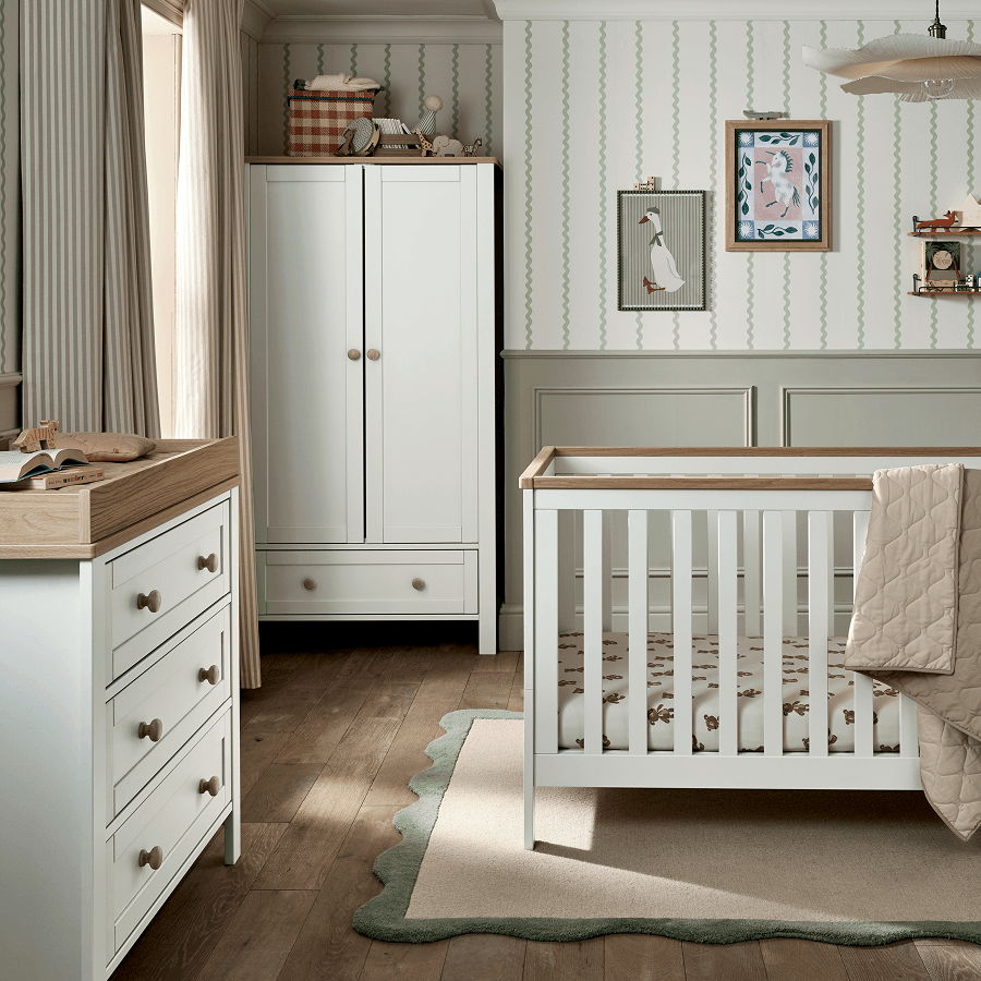 A cozy nursery featuring a crib, dresser, and wardrobe in soft colors.