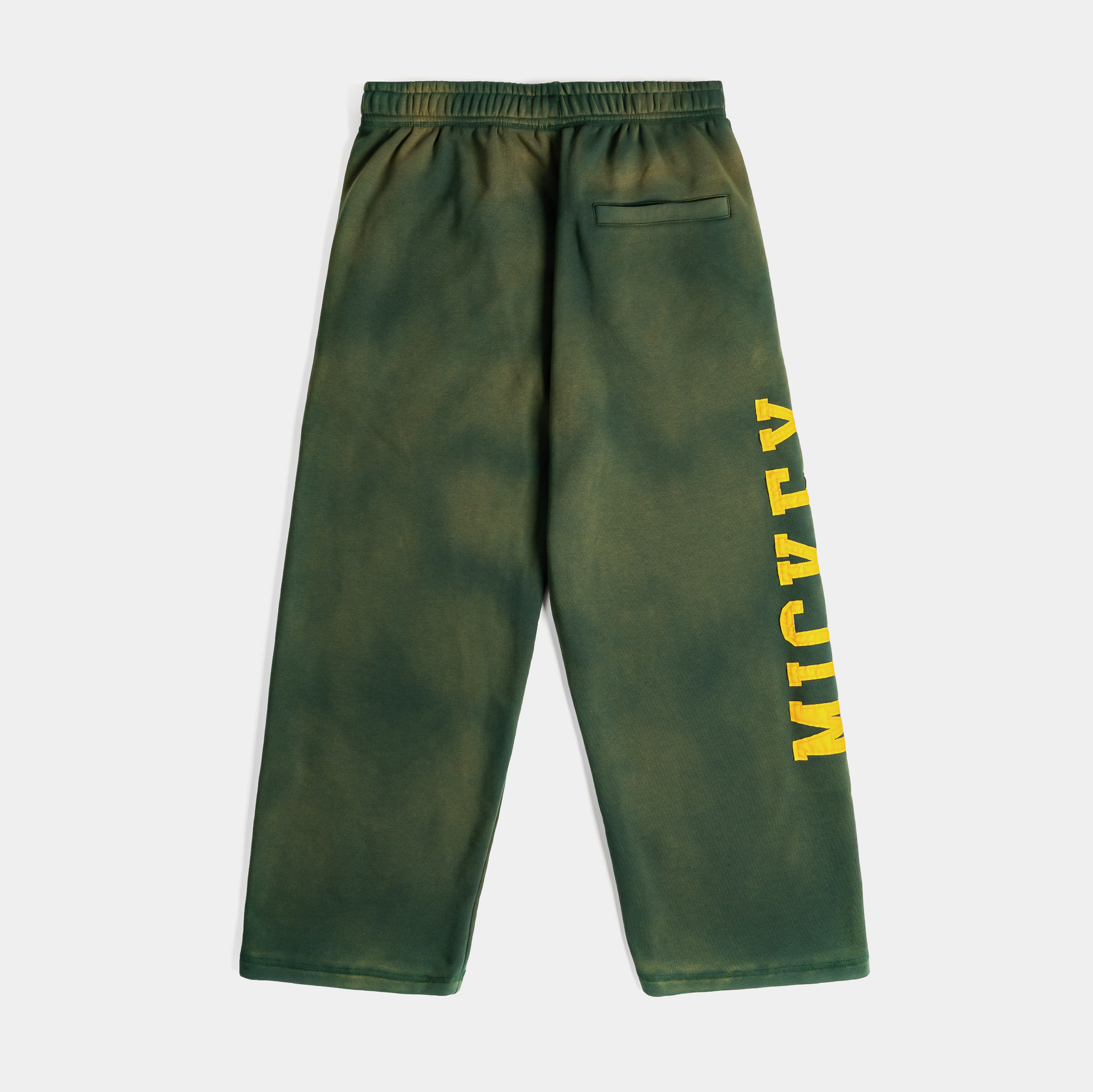 Green tie-dye pants with yellow text and a smiley face logo.