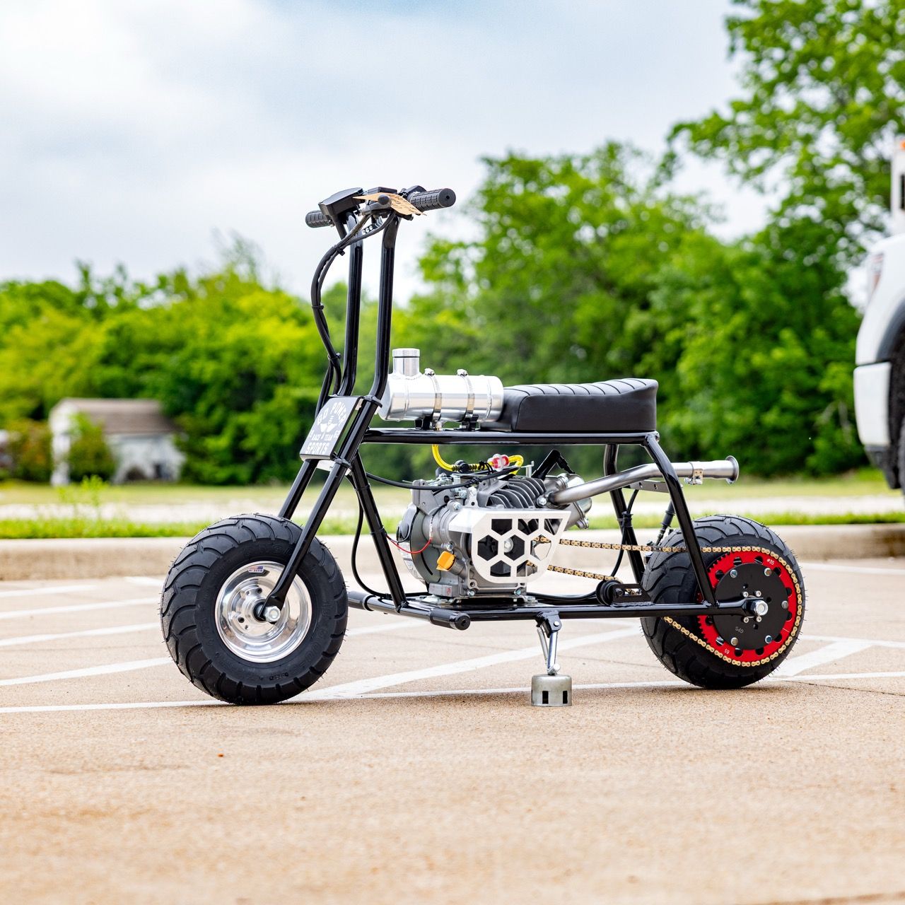 A compact motorbike with a chrome engine in an outdoor setting.