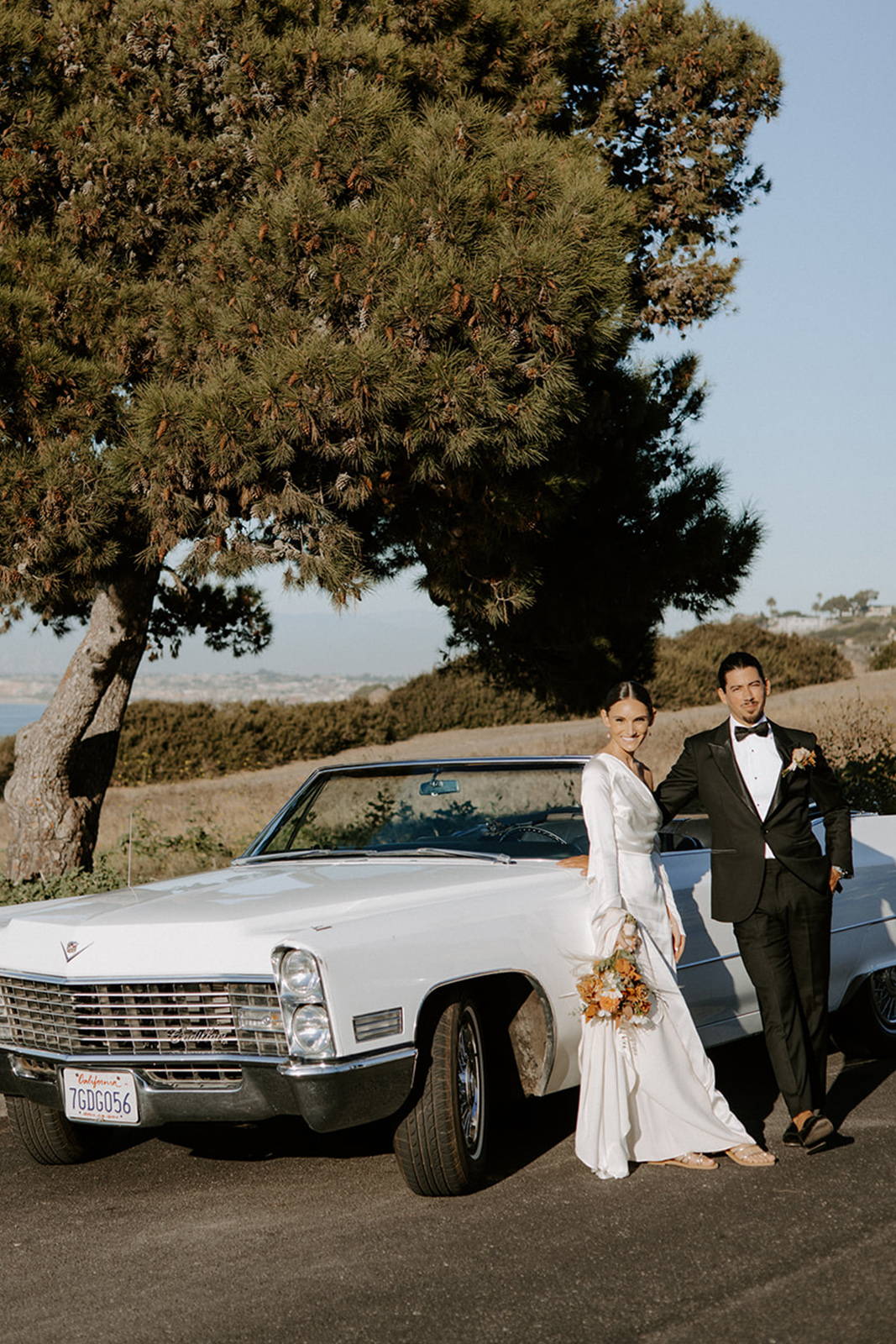 Bride and groom standing next to car