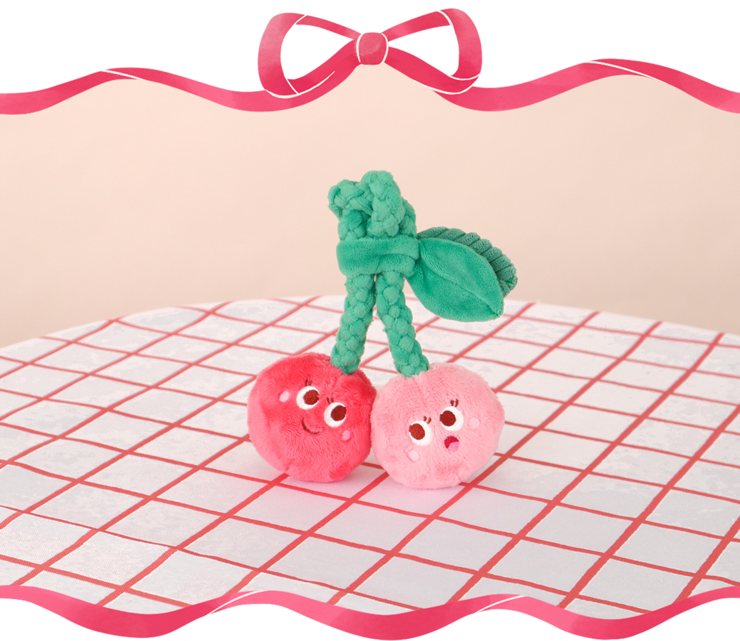 Two cute cherry figures with eyes on a checkered tablecloth.