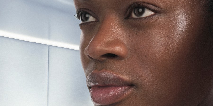 Close-up of a person's face with a neutral expression and glowing skin.