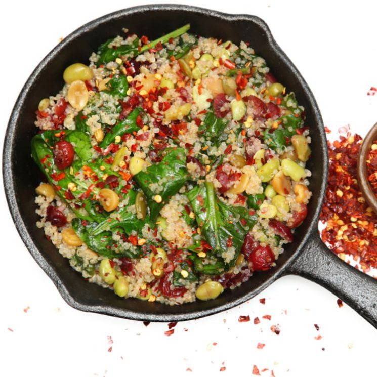 cast iron pan of quinoa spinach and cranberry side dish