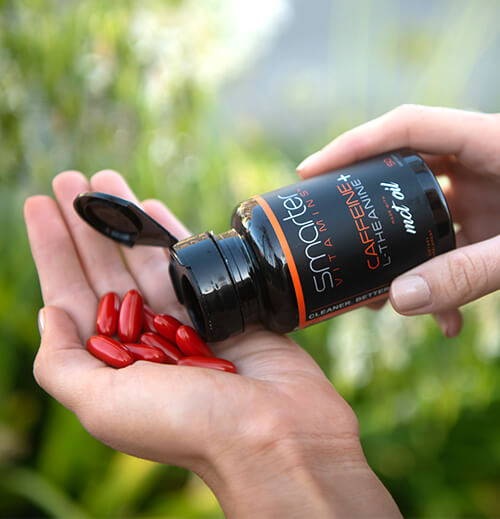 Opened Caffeine plus L-Theanine bottle in hand, pouring vitamins into other hand.