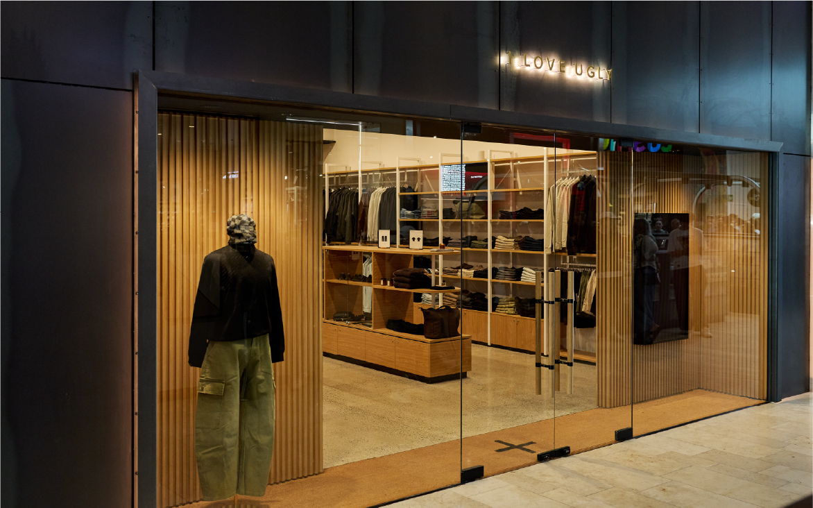 Clothing store entrance with displays and wooden interior.