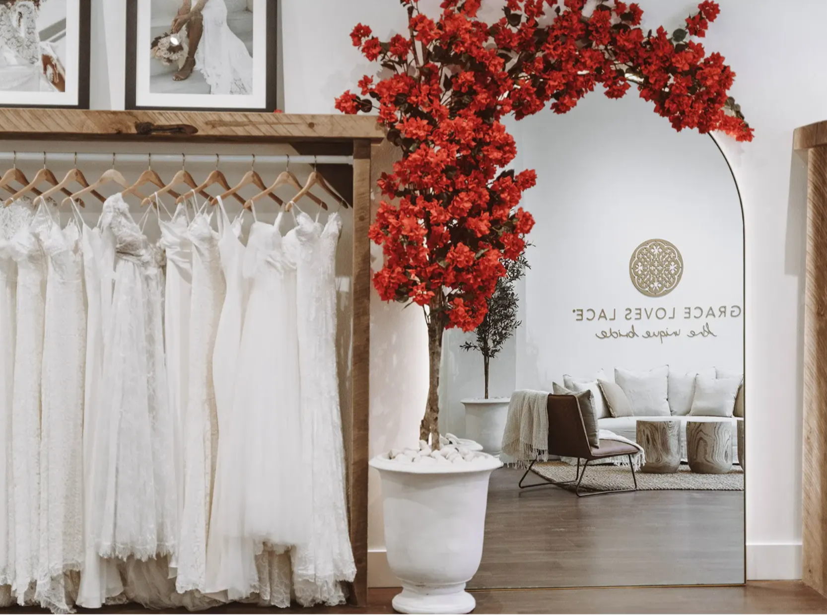 Rote Bougainvillea über einem Bogenspiegel in einem weißen Topf im Ausstellungsraum von Grace Loves Lace für Brautkleider