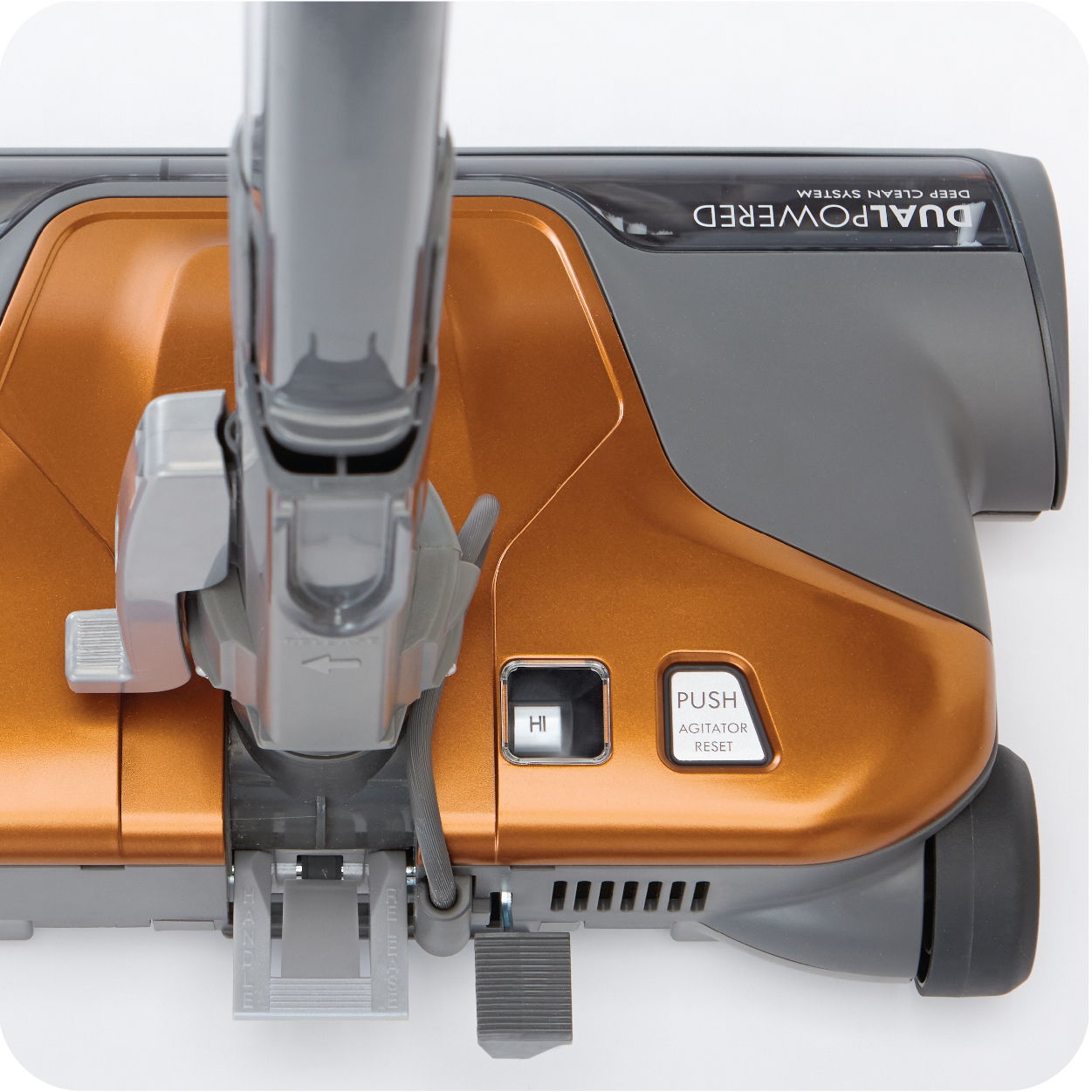Close-up of an orange vacuum cleaner nozzle and controls.