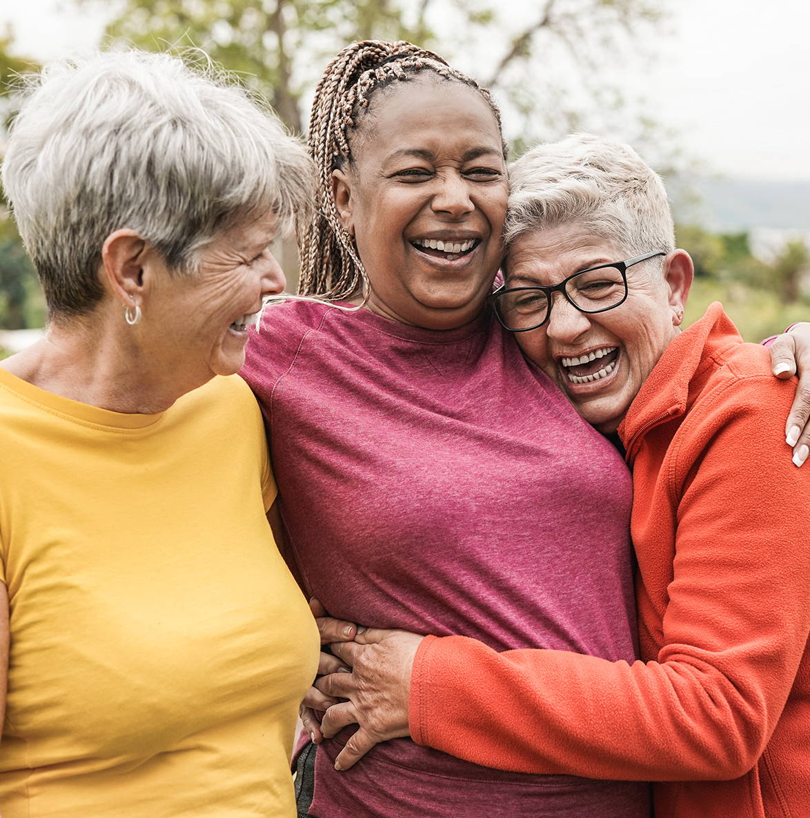 Group of three women hugging and laughing